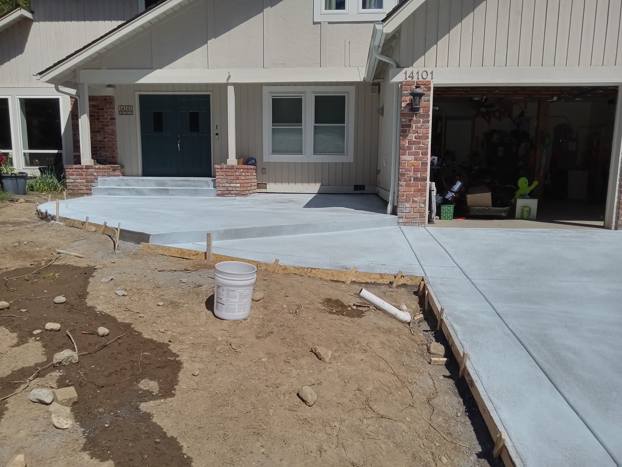 Freshly poured concrete driveway and front walkway at residential home