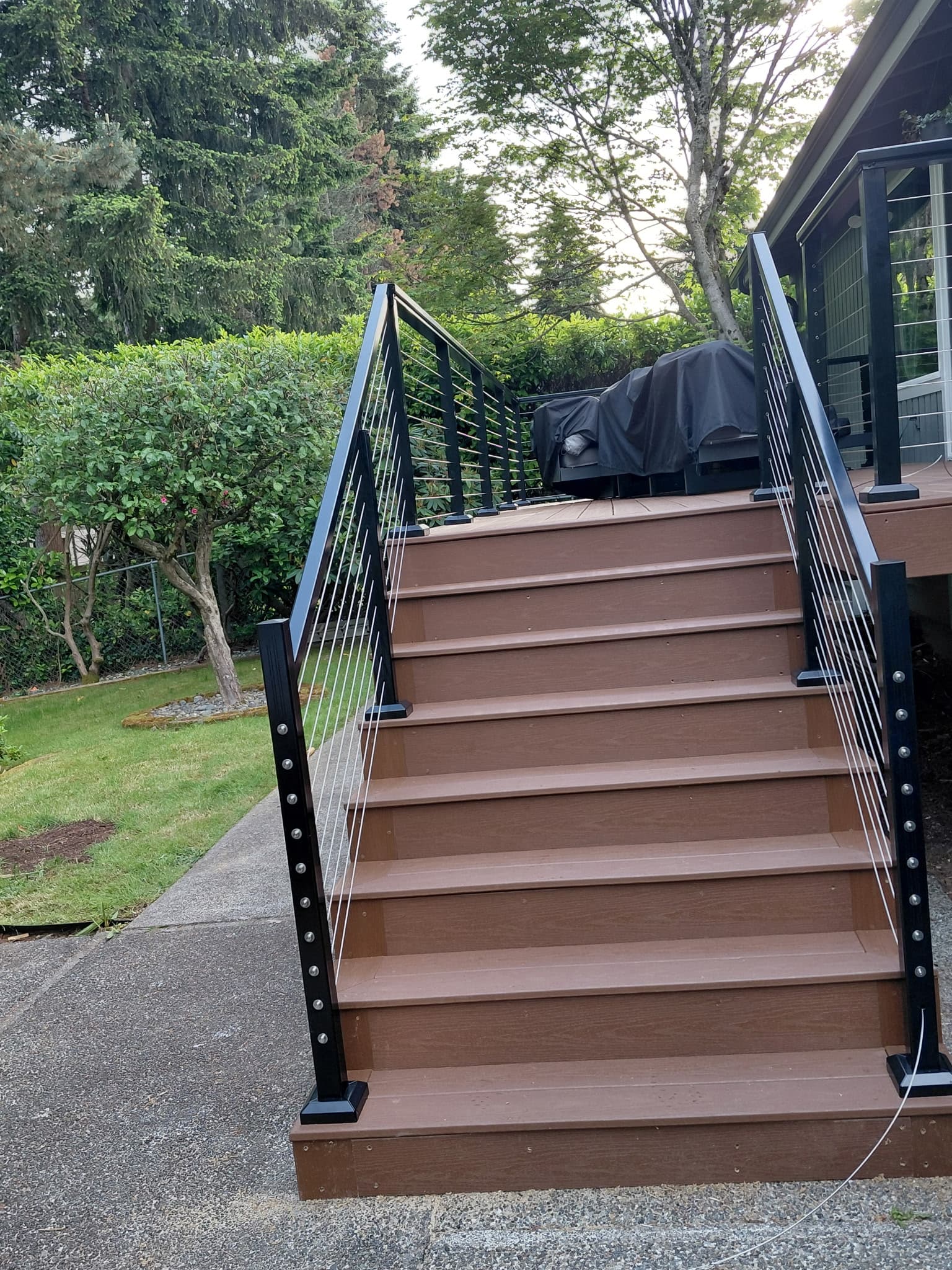 Composite deck staircase with cable railing from the front