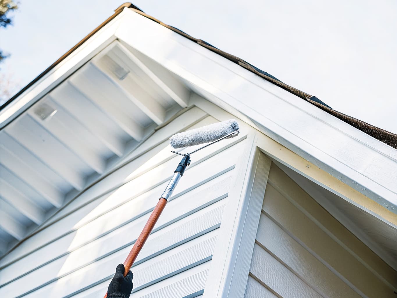 Exterior of a Pacific Northwest home being painted with a roller on extension pole