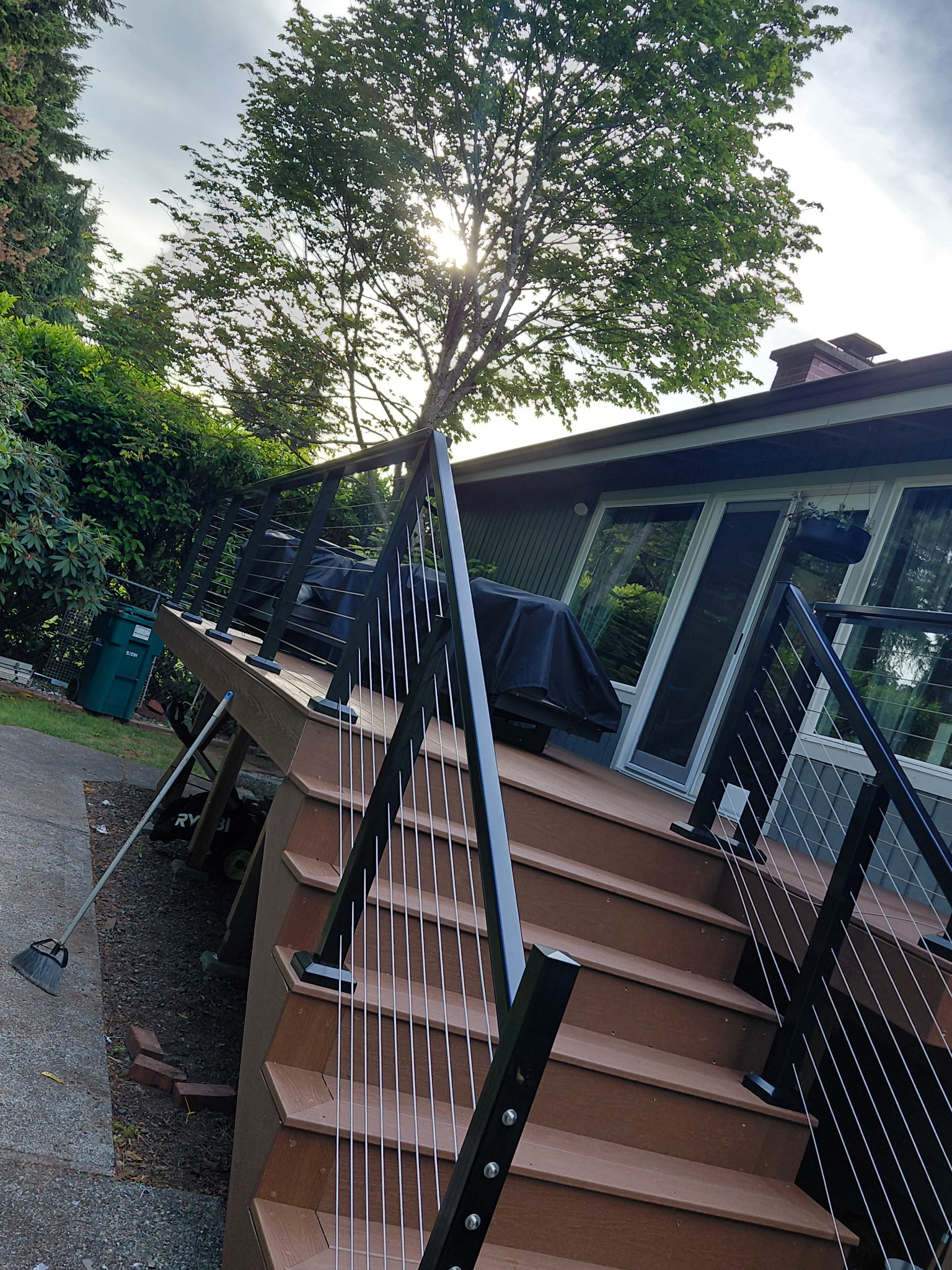 Dramatic angle of composite deck stairs with cable railing against the sky